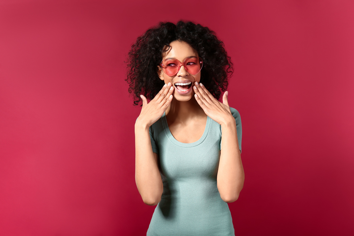 Happy African-American Woman on Color Background